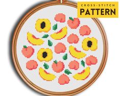 cross - stitch pattern with fruit and flowers in the center, on a white background