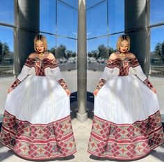 a woman in a white and red dress standing next to a tall building with large windows