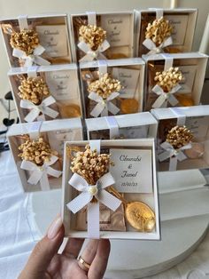 a person holding up a small box filled with cookies and candies in front of other boxes