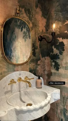 a white sink sitting under a bathroom mirror next to a wall mounted faucet