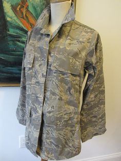 Indicated as Ladies size 4s, this US Air force camouflage jacket has lots of style (and warmth), very cool deep pockets, including pockets on the sleeves as well...machine washable, made of cotton/nylon, see tag on photo. Mannequin is ladies size 6-small 8. Camouflage Long Sleeve Utility Jacket For Outdoor, Camouflage Utility Jacket With Pockets, Camouflage Hooded Utility Jacket With Pockets, Military Style Outerwear With Side Pockets, Combat Style Camouflage Outerwear With Pockets, Combat Style Long Sleeve Utility Jacket For Fall, Winter Camouflage Utility Jacket With Pockets, Combat Style Utility Jacket With Long Sleeves For Fall, Camouflage Outerwear With Cargo Pockets For Fall