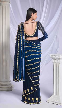 Our midnight blue pre-stitched sari, expertly crafted from a blend of georgette and tulle fabrics, features a delicate floral border adorning the tulle bottom, while the georgette pallu is elegantly embroidered with lines of pearls, metallic details, and acrylics. Paired with this sari is a georgette full-sleeve blouse, featuring metallic motifs and embellished with lines of pearls, golden bricks, and intricate motifs. Engagement Sarees, Reception Sarees, Papa Don't Preach, Haldi Dress, Full Sleeve Blouse, Celebrity Closet, Bridal Jumpsuit, Wedding Jumpsuit, Engagement Dresses