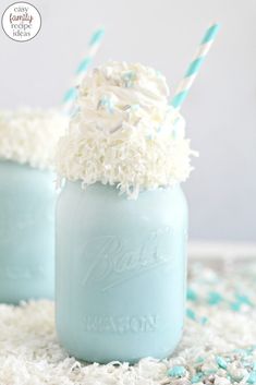 two mason jars filled with frosting and sprinkles on top of a table