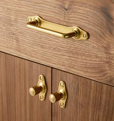 a close up of a wooden cabinet with brass handles and knobs on the doors