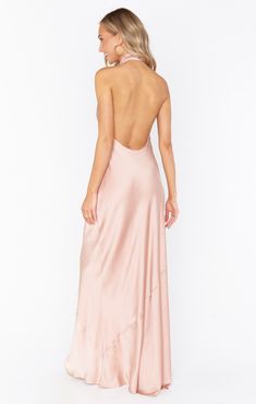 the back of a woman wearing a long pink dress with an open neckline and low cut