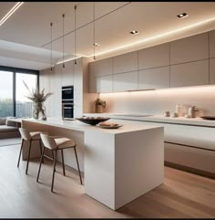 a modern kitchen with an island and seating area next to the window overlooking the city