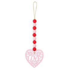 a pink and red heart ornament hanging from a string on a white background