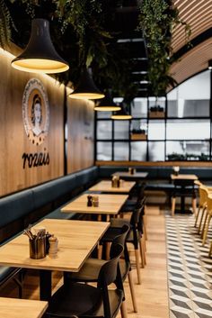 the interior of a restaurant with wooden tables and chairs