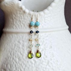 Ready made. Dramatic in color and design, these earrings display a selection of blue and green gemstones that bring to mind the coolness of a refreshing dip in the ocean or an energizing stroll through a spring meadow. ~ larimar, kyanite, Ethiopian opal, aquamarine, peridot ~ gold Blue Natural Stones Long Drop Jewelry, Blue Long Drop Natural Stone Jewelry, Blue Long Drop Jewelry With Natural Stones, Blue Dangle Birthstone Earrings, Blue Birthstone Earrings For Jewelry Making, Blue Birthstone Earrings For Crafting, Blue Birthstone Dangle Earrings, Blue Drop Earrings With Natural Stones, Cheap Gold Jewelry