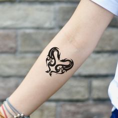 a woman's arm with a tattoo on it that has a heart in the middle