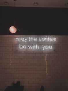 a neon sign that reads, may the coffee be with you on a tiled wall