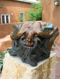 a statue of a man laying on top of a rock