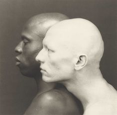 two bald men facing each other in black and white