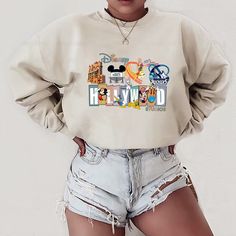 a woman wearing shorts and a sweatshirt with cartoon characters on it