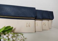 three white and blue bags sitting on top of a table next to a bouquet of flowers