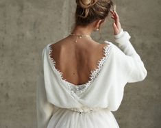 the back of a woman's wedding dress, with her hair in a bun