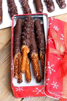 chocolate covered pretzels are in a red box with a bow on the side