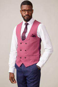 Lift your look with this Kelvin waistcoat in a vibrant raspberry shade. The bold pink colour ties in perfectly for a summer wedding look and makes for an effortless styling piece for mix-and-match. The bespoke MD paisley print lining adds elegance and the textured design keeps it on trend. With adjuster buckles to either side you'll be able to nip in where necessary. Also available in a single-breasted option. Model wears size 38R. Features Slim fit Double-breasted 3x2 button fastening Complimen Pink Tailored Three-piece Suit With Notch Lapel, Tailored Pink Three-piece Suit With Notch Lapel, Pink Fitted Sleeveless Vest, Classic Tailored Pink Three-piece Suit, Pink Tailored Classic Three-piece Suit, Pink Slim Fit Suit For Semi-formal Occasions, Pink Slim Fit Suit For Business, Pink Slim Fit Business Suit, Fitted Spring Suit With Vest