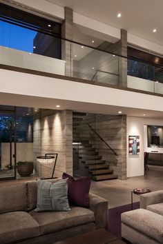 a living room filled with lots of furniture next to a stair case in front of a window