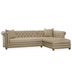 a large beige sectional couch with pillows on it's back and armrests