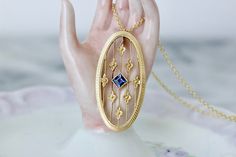 This enchanting antique pendant is made from an Art Deco era brooch and is crafted in 14k yellow gold. It features a beautiful step cut sapphire in the dreamiest cornflower blue (most likely synthetic as this was very popular at the time, and understandably so 💙). The gem is bezel set at the center of the piece, with the sweetest four petaled posies suspended around it upon delicate golden threads. The oval frame is engraved with a wavy, flowing border that compliments the color of gem as well. This pendant was converted by Thomas himself and the end result is a truly one of a kind necklace. It can be purchased with or without the 14k gold chain it is shown on. The chain is new stock with an upgraded lobster clasp, and can be worn at 18 or 16 inches.  MAIN STONE: Synthetic Blue Sapphire Antique Engagement Rings Vintage, Floral Filigree, Blue Sapphire Pendant, Deco Blue, Filigree Necklaces, Antique Pendant, Step Cut, Sapphire Pendant, Antique Engagement Rings