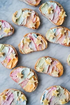 several pieces of bread with different colored toppings on them sitting on a marble surface