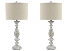 two clear glass table lamps with beige linen shades on each lamp and one is turned off