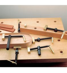 a wooden work bench with several different tools on it and some wood pegs attached to the board