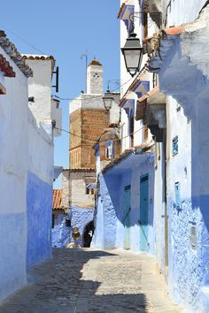 an alley way with blue and white buildings