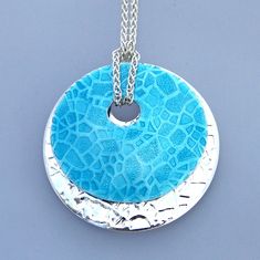 Lake Bed enamel pendant necklace has two circle embossed discs, one colored turquoise, one sterling silver. White Gold Enamel Necklaces, Blue Enamel Engraved Necklace, Blue Enamel Necklaces With Lobster Clasp, Blue Engraved Enamel Necklaces, Blue Engraved Round Pendant Necklace, Nickel-free Enamel Pendant Necklace, Nickel Free Enamel Pendant Necklace, Hypoallergenic Round Enamel Jewelry, Silver Enamel Oval Pendant Jewelry