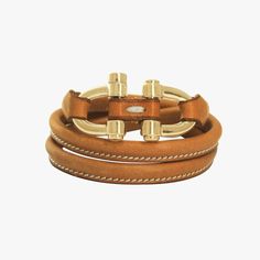 This luxuriously gold-plated or silver-plated bracelet, featuring tubular leather, a polished edge, painted details, and intricate reworking, has been manually polished three times to achieve its ideal sheen. Boasting hand-stitching and one size that fits wrists from 15 to 18 cm, it is a truly exquisite piece. Modern Bracelets With Gold-tone Hardware, Designer Gold Bracelets With Gold-tone Hardware, Elegant Leather Bracelets With Gold Clasp, Luxury Adjustable Leather Bracelet For Everyday Wear, Adjustable Brown Timeless Jewelry, Designer Yellow Gold Adjustable Bracelets, Luxury Everyday Leather Bracelet, Adjustable Leather Bracelet With Gold Clasp, Modern Adjustable Bracelets With Gold-tone Hardware