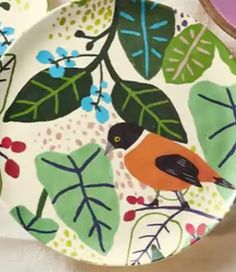 two plates with birds and leaves painted on them