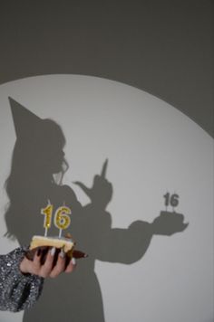 a shadow of a person holding a cake