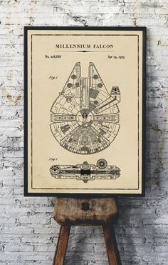 the millennium falcon blueprint is on display in front of a white brick wall and wooden stool