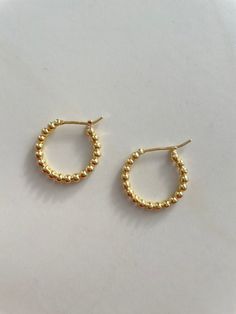 Gold bead hoop earrings. Beads hug the shape making a classic hoop. Earrings measures approximately 3/4” 14kt Gold vermeil, lead and nickel free Each piece is unique in color and may vary from the picture Business Earrings, Unique Gold Earrings, Business Jewelry, Bead Hoop Earrings, Earrings Beads, Layered Jewelry, Beaded Hoop Earrings, Beaded Hoops, Metal Work