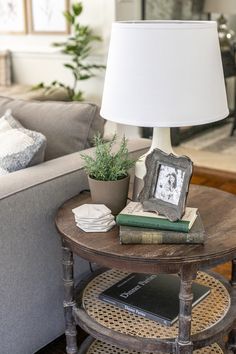 a living room with a couch, coffee table and lamp on top of the table