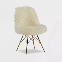 a white chair with metal legs and fur on it