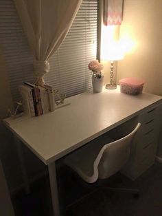 a white desk with a lamp on top of it and some books next to it