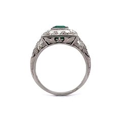 1.07 Art Deco Emerald Diamond Cocktail Ring in Platinum. This illuminating Art Deco ring features a 1.07 carat emerald and .66 carats of Old European cut diamonds in shimmering platinum. The emerald has a vibrant, sea green hue and is set in a square bezel. The emerald is haloed by twenty-two (22) .03 carat OEC diamonds on the head and shoulders of the band. Fine milgrain details decorate the rectangular head of the ring. From the profile, a decorative basket mounting holds the stones, finished Sapphire Color, Metal Shop, Diamond Cocktail Rings, European Cut Diamonds, Shop Engagement Rings, Art Deco Ring, Emerald Diamond, Cocktail Rings, Shop Necklaces