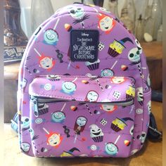 Loungefly The Nightmare Before Christmas Character Candy Mini Backpack, Nwot, Excellent New Condition. Jack Sally Spring. No Tricks Here, Only Treats! Your Favorite Characters From The Nightmare Before Christmas Have Been Turned Into Candy And Desserts. This Purple Mini Backpack Has Oogie Boogie And Shock As Cupcakes, Jack And Sally As Lollipops And Lock And Barrel As Candy Apples. Adjustable Straps, Front Zipper Pocket And Interior Drop Pocket. 8 1/2" X 4 3/4" X 10" Polyurethane Imported Nightmare Before Christmas Character, Nightmare Before Christmas Characters, Loungefly Bag, Oogie Boogie, Jack And Sally, Christmas Characters, The Nightmare Before Christmas, The Nightmare, Candy Apples