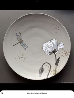 a white plate with dragonflies and flowers on it