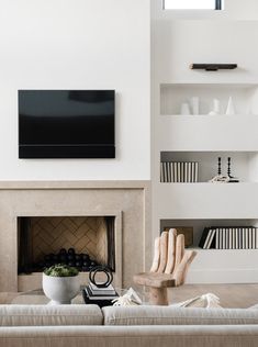 a living room filled with furniture and a flat screen tv mounted on the wall above a fireplace