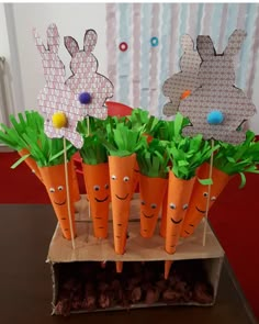 carrots with faces made out of paper and grass