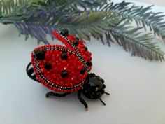 a red and black beaded lady bug sitting on top of a table