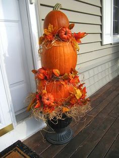 a large pumpkin sitting on top of a black pedestal next to a white door way