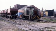 an old train sitting on the tracks next to a building