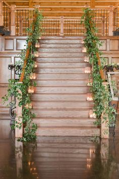 the stairs are decorated with candles and greenery