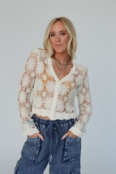 Wrap yourself in the timeless charm of our Ipanema Flower Crochet Cardigan whether paired with jeans for a casual outing or layered over a dress for a touch of bohemian chic, this sweater is sure to become a wardrobe favorite! So pretty and unique floral crochet fabric Relaxed and loose cardigan silhouette Flattering v - neckline with a button - up front closure Loose long sleeves Ribbed scalloped trim along the bottom edge, wrists, neckline, and front closure Pair with: Eye Of The Sun Padded Br Luxury Beige Bohemian Cardigan, Crochet Flower Cardigan, Boho Essentials, Flower Cardigan, Bralette Outfit, Loose Cardigan, Crochet Buttons, Flower Crochet, Crochet Fabric