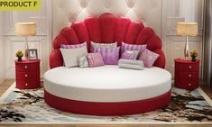 a red and white round bed sitting on top of a wooden floor next to two nightstands