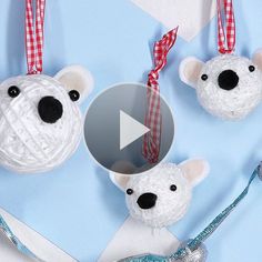 three crocheted polar bear ornaments hanging from strings on a blue and white background